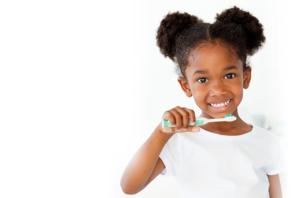 Child brushing teeth to promote healthy smiles