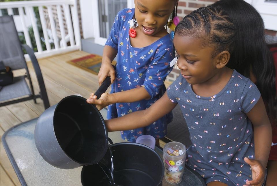 Children age 0-3 playing kitchen outside.
