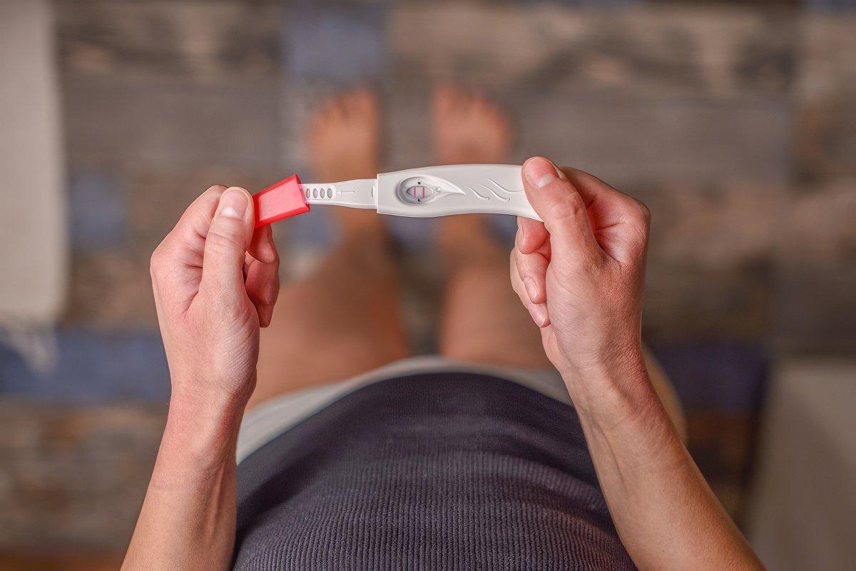 Woman checking a pregnancy test. What if you got pregnant before you were ready?